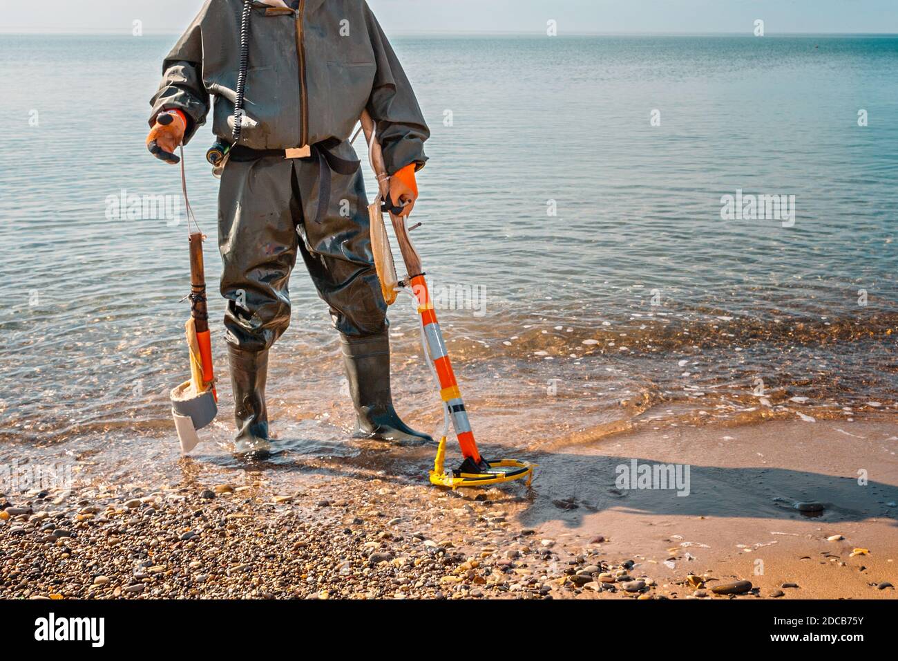 Un uomo con un metal detector si trova sulla spiaggia, pronto per nuovi  ritrovamenti archeologici. Mare sullo sfondo Foto stock - Alamy