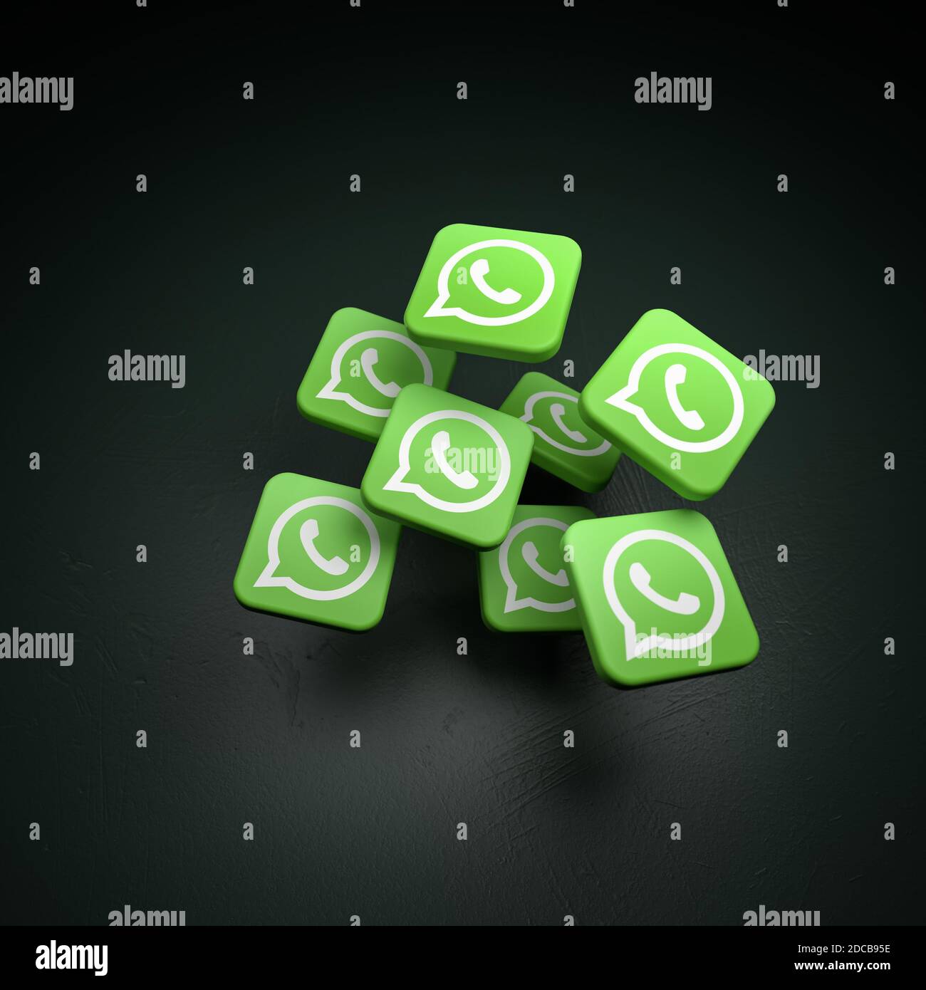 Logo del sito di messaggistica e app whatsapp (parte di facebook) che cadono su un tavolo scuro. Spazio di copia Foto Stock