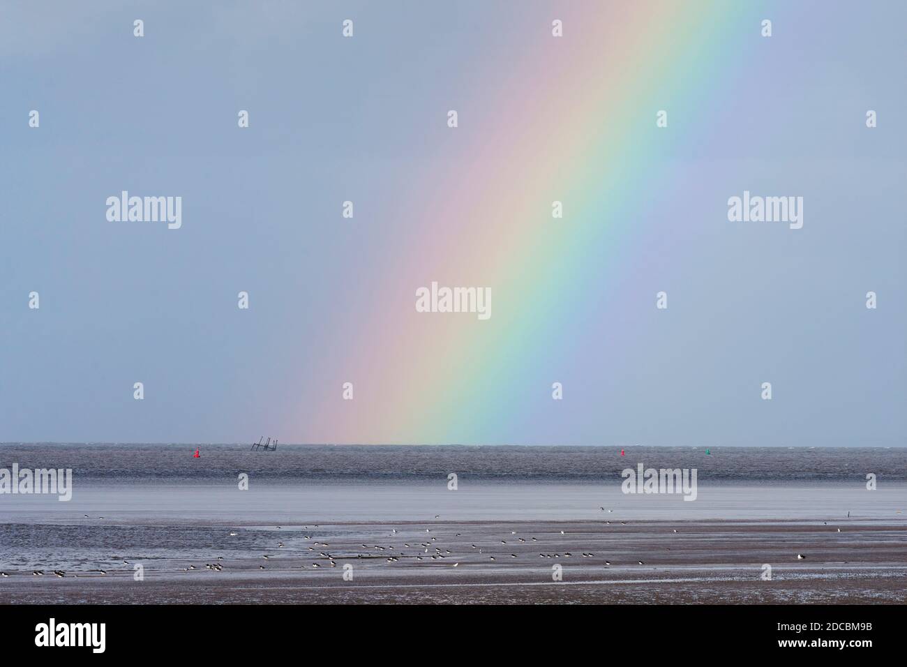 Rainbow termina con la lista dei resti del Wyre Light, un faro di 40 metri di altezza in ferro con pelo a vite, Morecambe Bay, Lancashire, Regno Unito Foto Stock