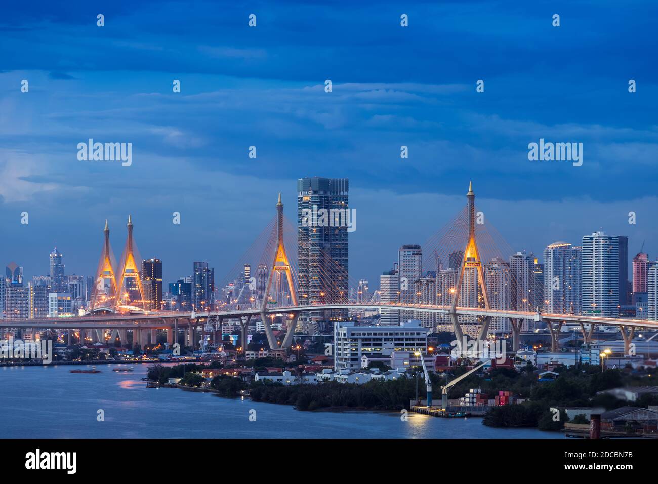 Grande ponte sospeso sul fiume Chao Phraya al crepuscolo, con la città sullo sfondo Foto Stock