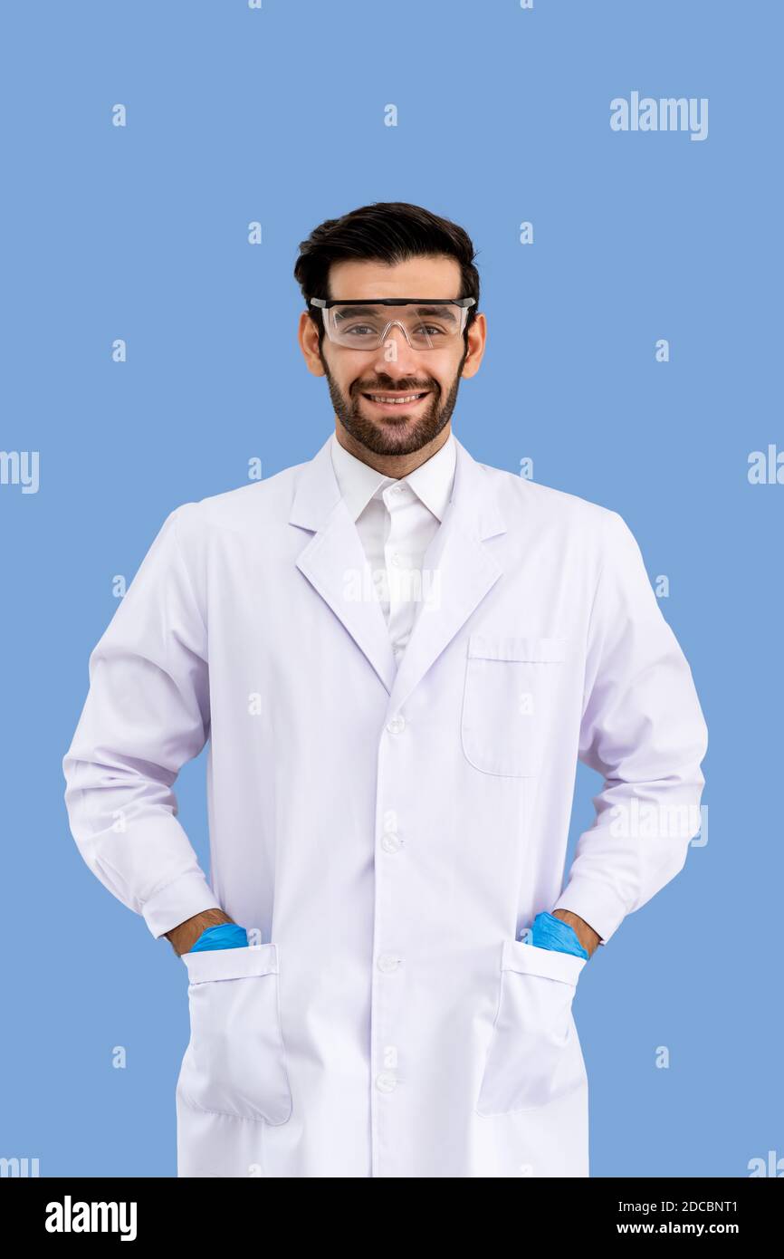 Ritratto di sicuro ricercatore arabo medio orientale maschile scienziato medico medico che indossa occhiali di protezione in piedi e mettere le mani in tasche isola Foto Stock