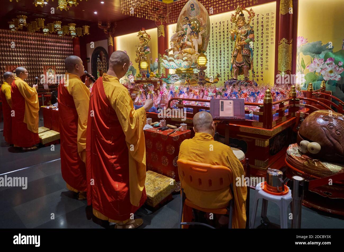Sacerdoti buddisti che conducono preghiere al Tempio e Museo della reliquia del dente di Buddha a Chinatown, Singapore Foto Stock