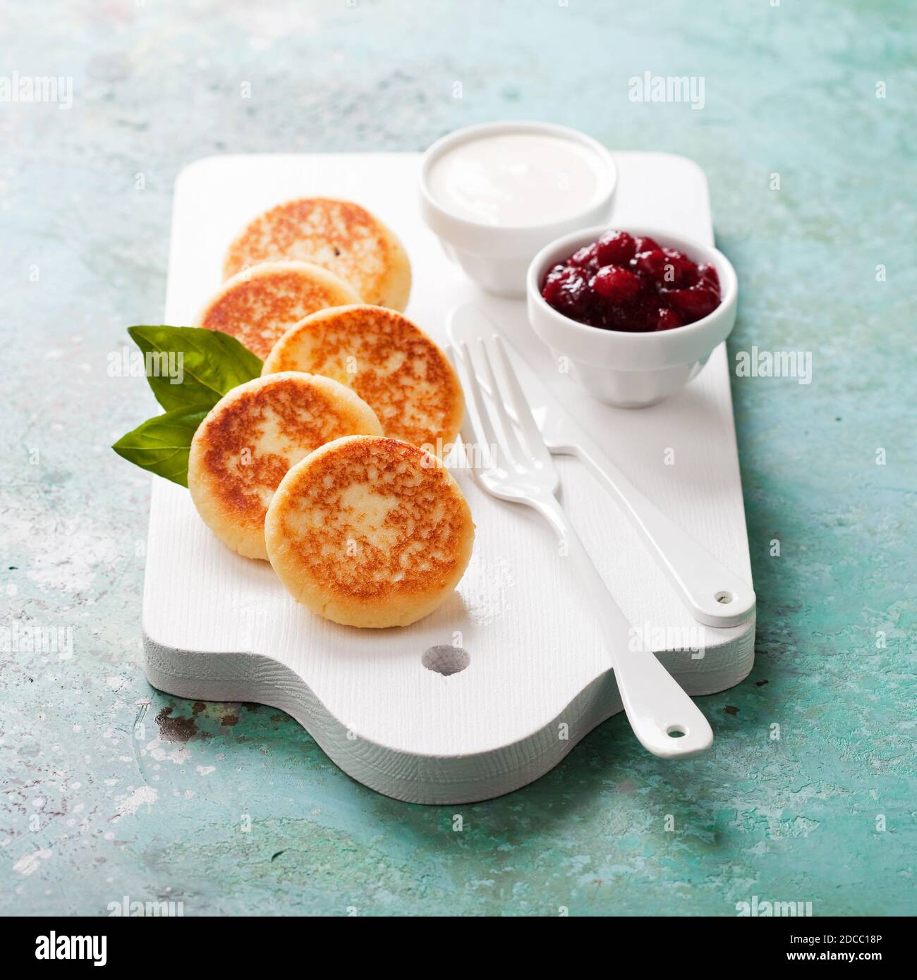 Frittelle al formaggio Russo scirniki con confettura di mirtilli e yogurt, fuoco selettivo Foto Stock