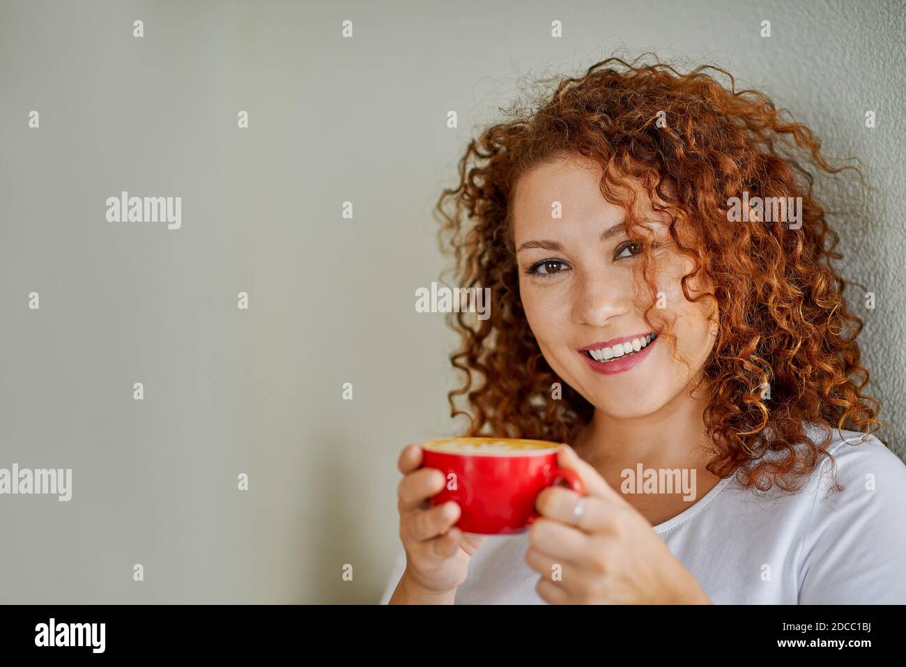Giovane donna che gusta un caffè Foto Stock