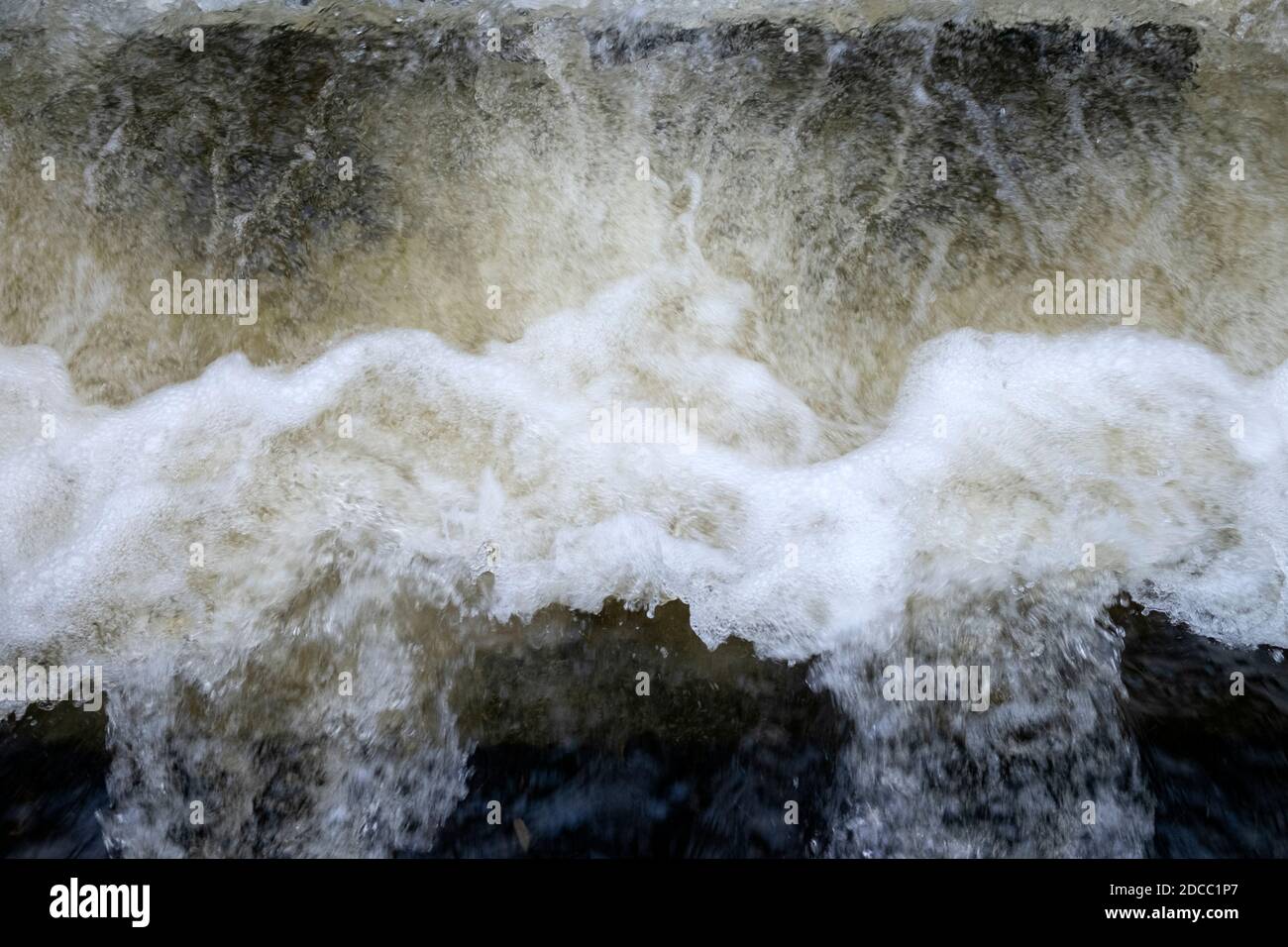 Schiuma turbolenta acqua frizzante che scorre in un ruscello in autunno Novembre Rural Carmarthensshire Galles Gran Bretagna Regno Unito KATHY DEWITT Foto Stock