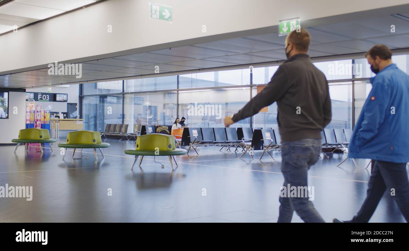Vienna, Vienna/Austria - 2 novembre 2020: I passeggeri camminano fino alle porte di partenza dell'aeroporto di Vienna. Solo poche persone in viaggio e molte sono chiuse Foto Stock