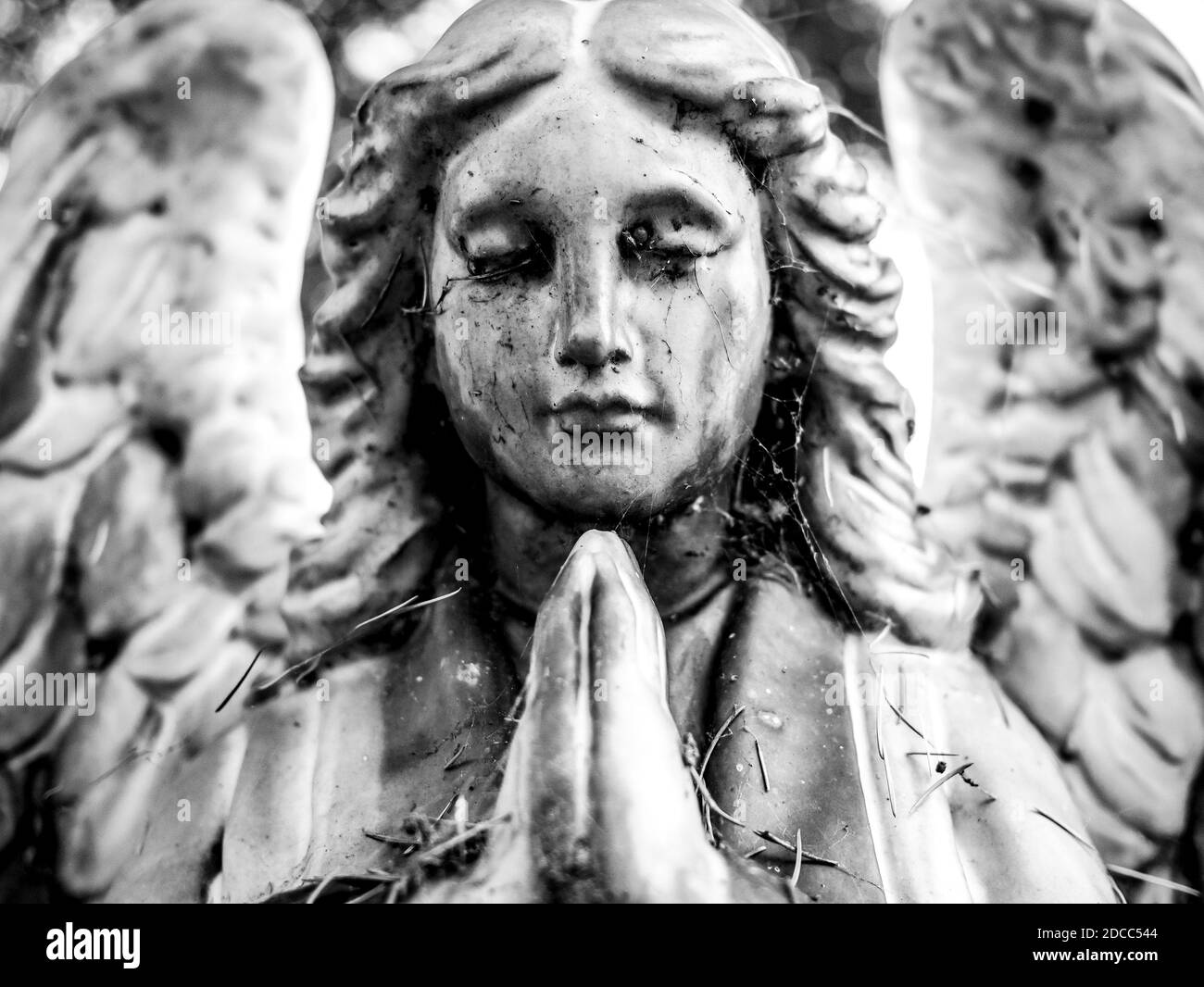 Lapide di un angelo che prega in bianco e nero Foto Stock