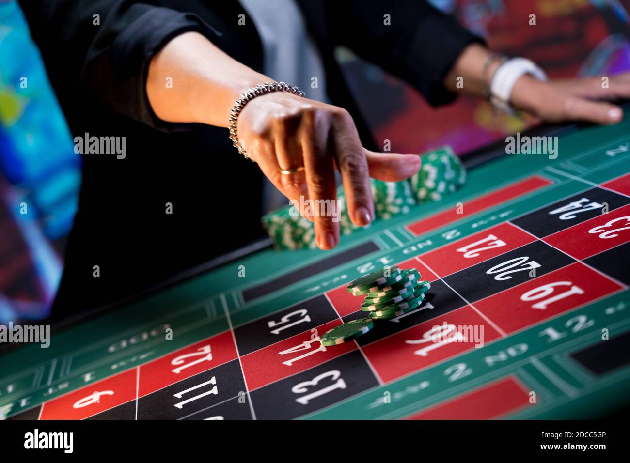 Donna che gioca al tavolo della roulette al casinò Foto Stock