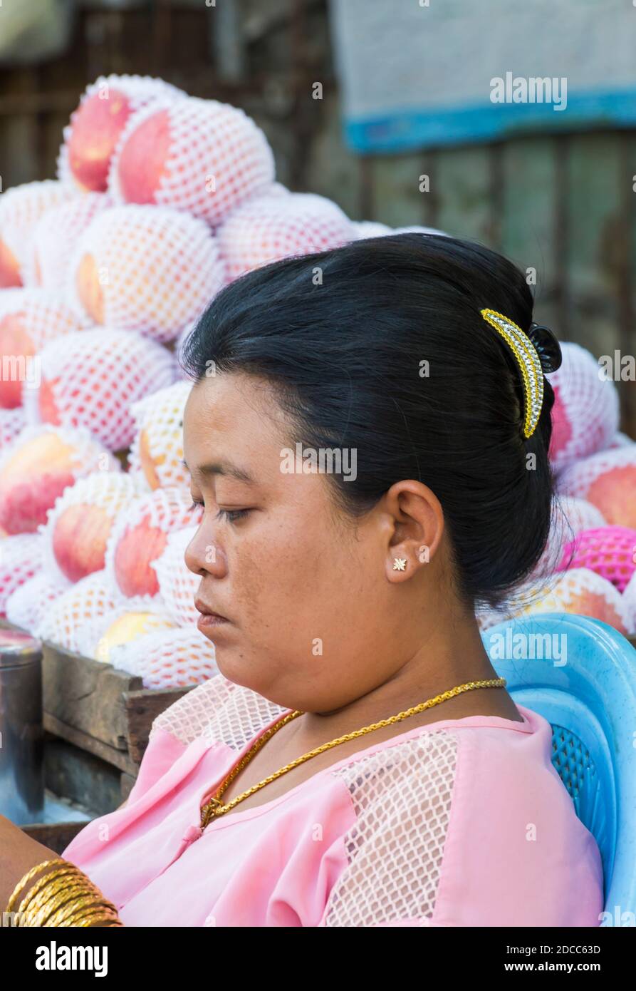 La vita quotidiana in Myanmar - la donna stalla titolare con frutta in background a Yangon, Myanmar (Birmania), Asia nel mese di febbraio Foto Stock