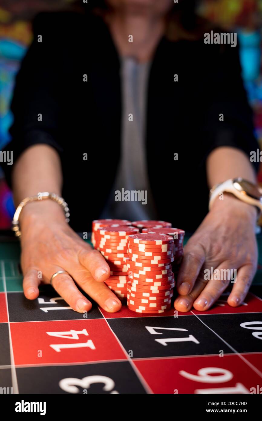 Donna che gioca al tavolo della roulette al casinò Foto Stock