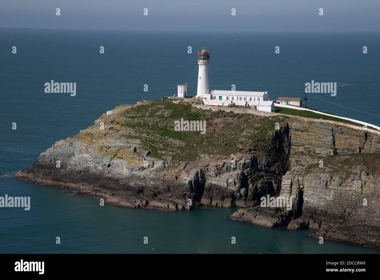 Una vista del faro di South Stack costruito sulla cima di una piccola isola al largo della costa nord-occidentale di Holy Island, Anglesey, Galles del Nord. Foto Stock