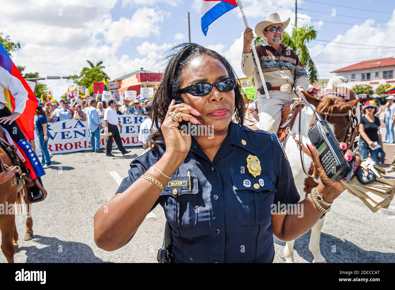 Miami Florida,Little Havana,uomini ispanici,Calle Ocho protesta politica Fidel Castro Hugo Chavez,firma striscioni marciando venezuelani cubani,Black Afr Foto Stock