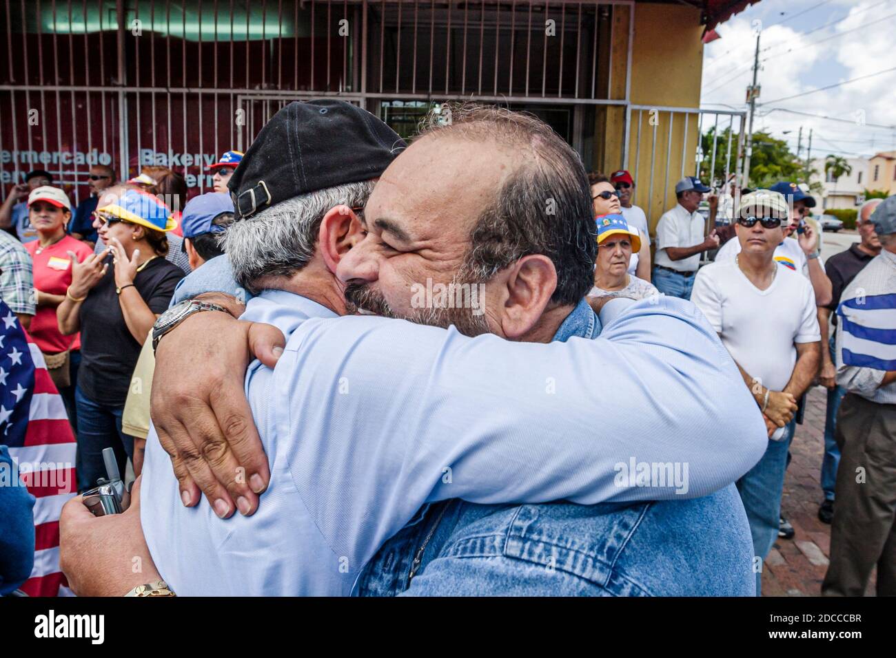 Miami Florida,Little Havana,uomo ispanico uomini, Calle Ocho protesta politica Fidel Castro Hugo Chavez, segni striscioni marching venezuelani Cubani saluto Foto Stock