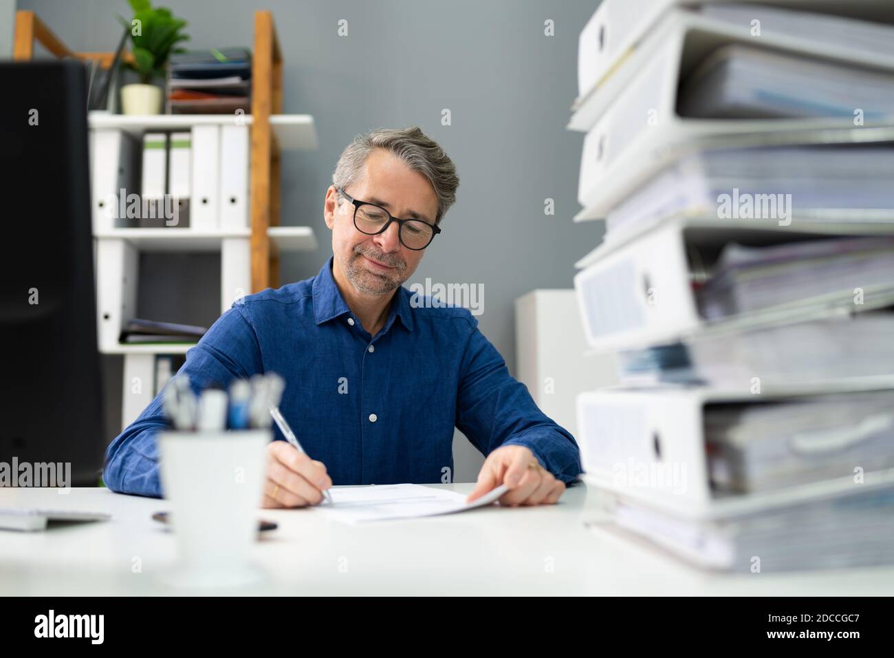 Uomo d'affari del commerciante professionista felice alla scrivania professionale corporativa Foto Stock