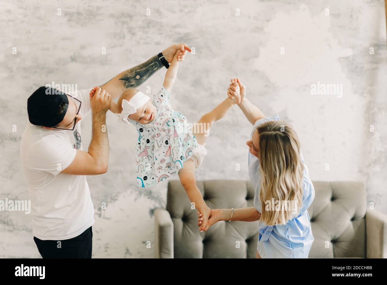 I giovani genitori si divertono e giocano con la loro bambina. Foto Stock