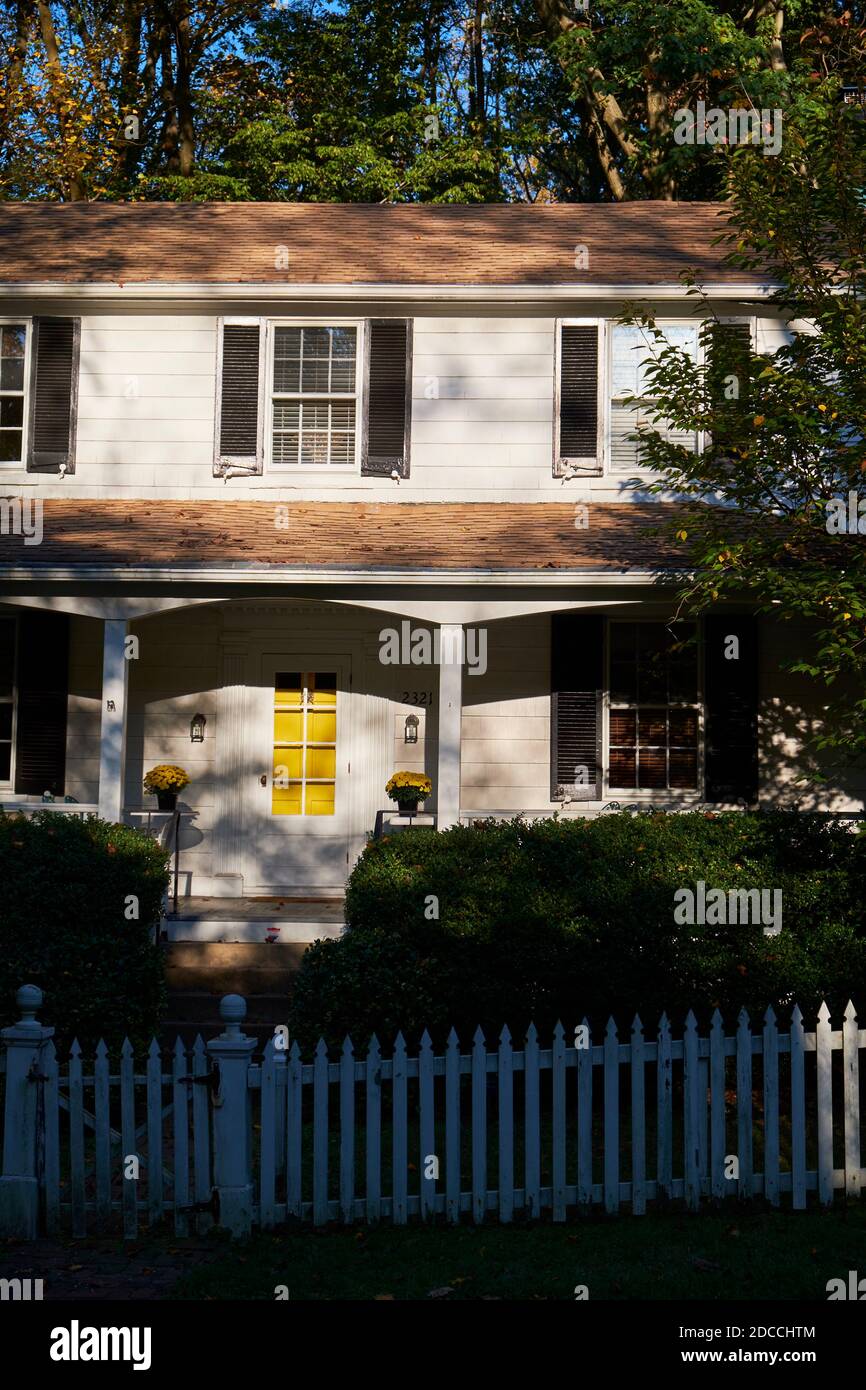 Recinto bianco picket e una casa su una strada a Dickeyville, l'epoca coloniale, storico mulino città. A Baltimora, Maryland durante l'autunno. Foto Stock