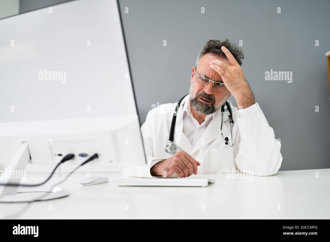 Vecchio uomo triste Dottore stress e dolore al computer Foto Stock
