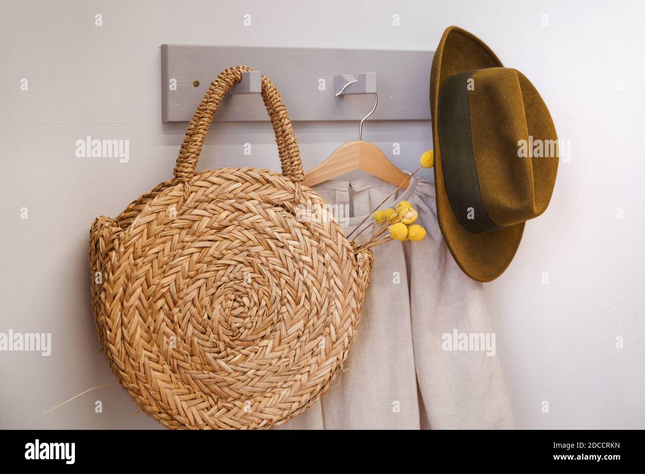 Cappello e borsa di paglia da spiaggia su un appendiabiti rustico Foto Stock