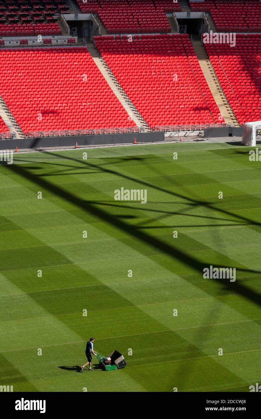 Un falciatore taglia l'erba al Wembley Stadium, Wembley, Londra. Foto Stock