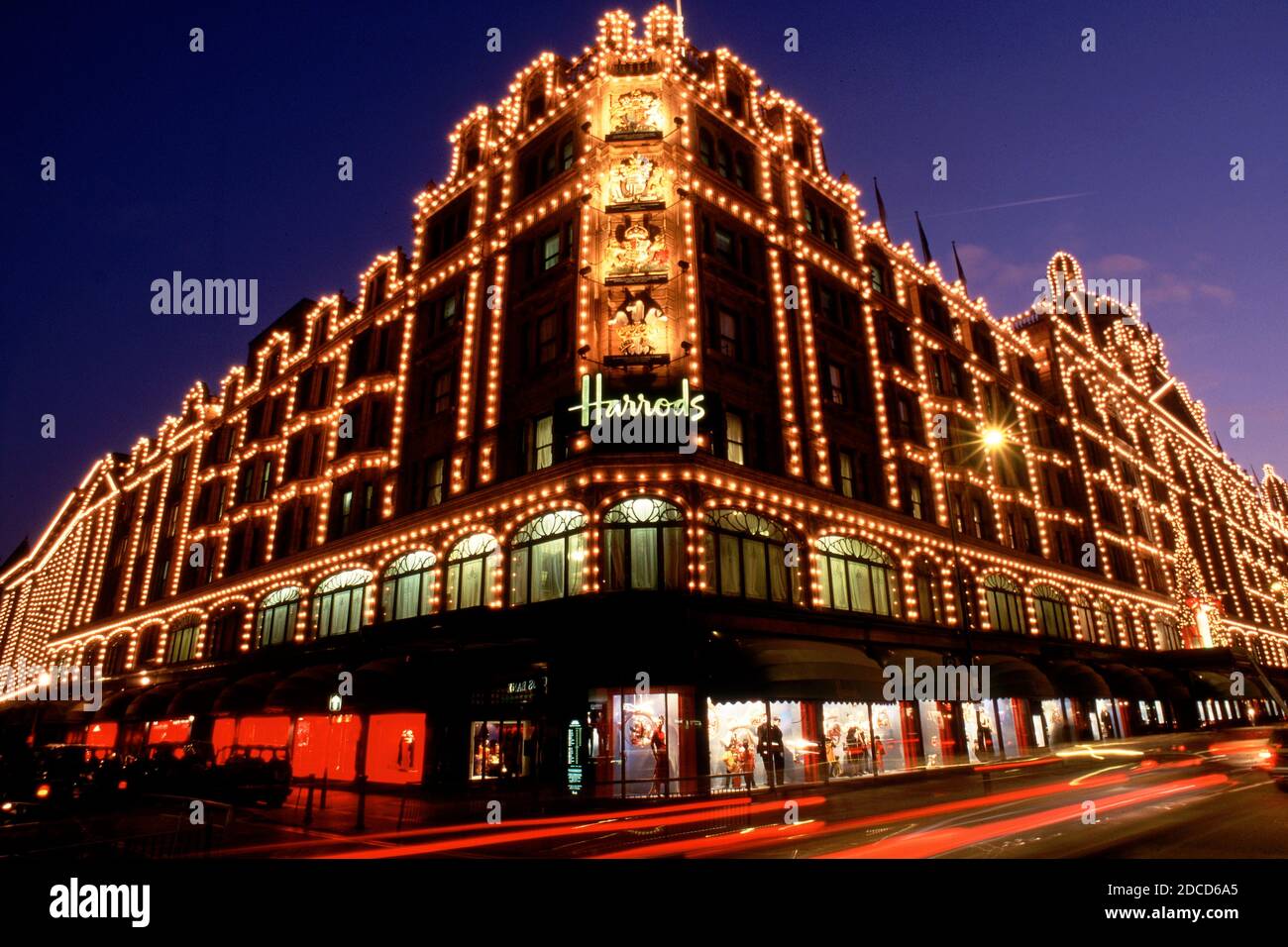 Londra, Regno Unito, esposizione lunga del grande magazzino Harrods a Londra durante la notte con traffico stradale Foto Stock