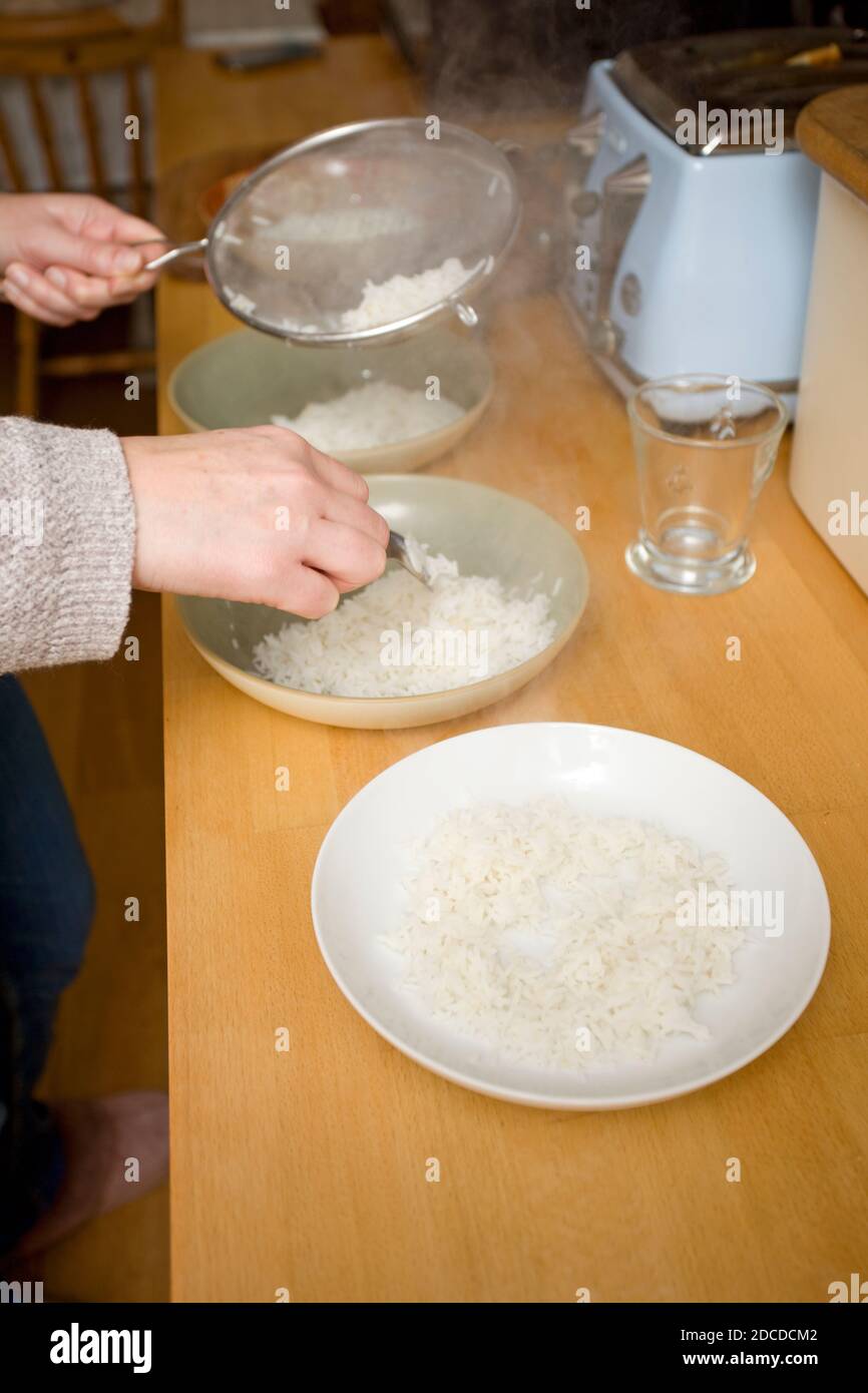 Immergi il riso cotto in ciotole Foto Stock