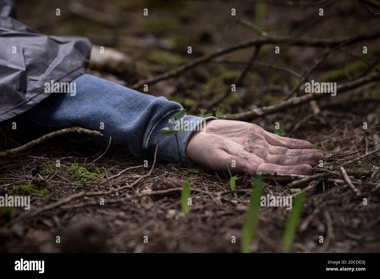 Mano di un uomo morto sul terreno nei boschi. Uomo assassinato Foto Stock