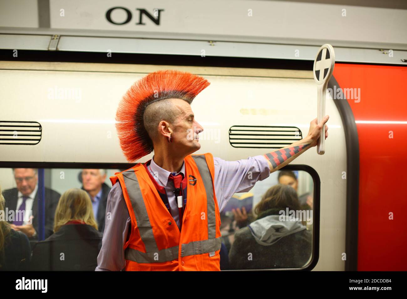 London Underground worker e Punk Greg con luminoso arancione mohawk hairstyle.Tube lavoratore sotterraneo hairstyle mohican mohawk. Foto Stock