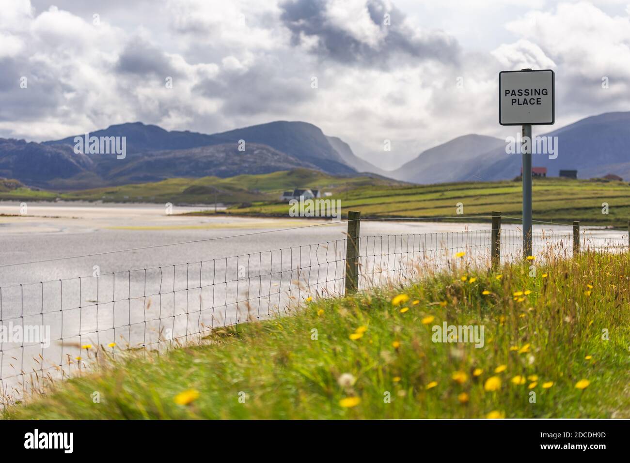Splendido scenario scozzese di passaggio segno posto di fronte alla spiaggia di Uig con colline e valli in lontananza. Foto Stock