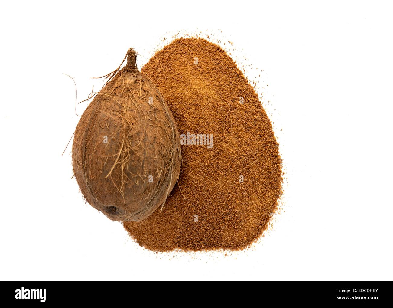 zucchero di cocco organico in un mucchio con un cocco intero isolato su sfondo bianco Foto Stock