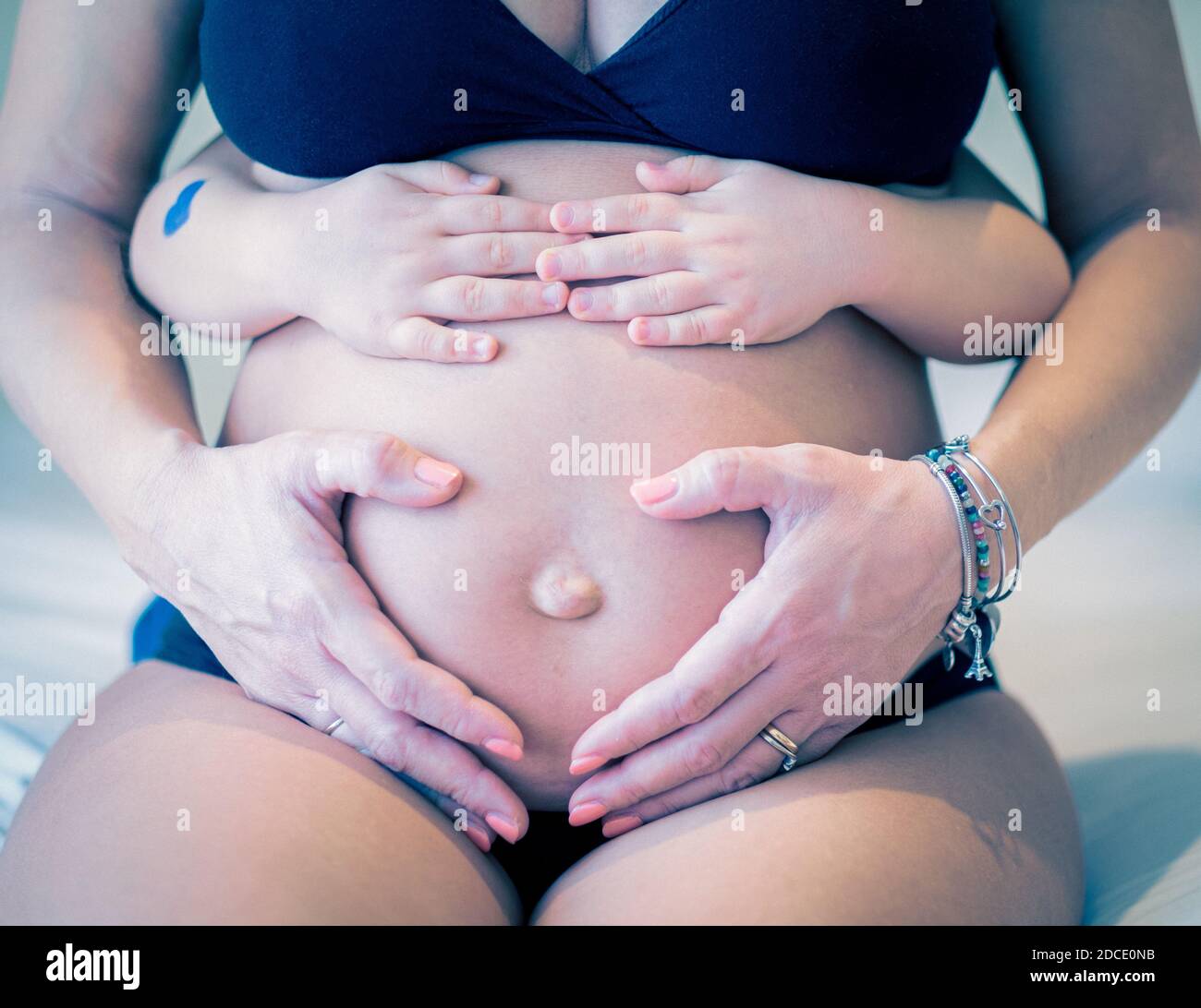 Primo piano immagine della donna incinta e del suo bambino che tiene Il suo ventre - Bambino che tiene il ventre della sua incinta Madre - donna incinta e il suo bambino holdin Foto Stock