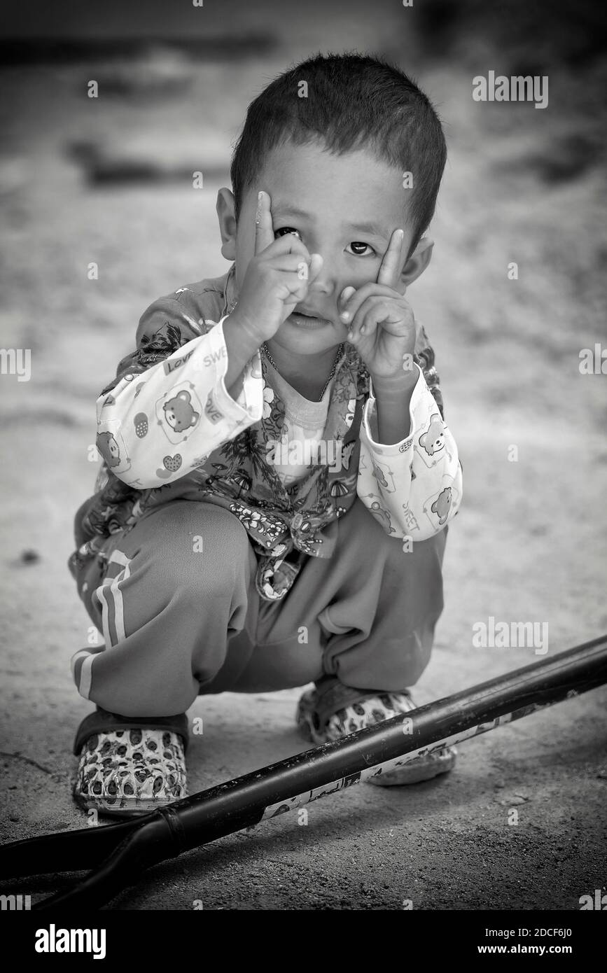 Bambino divertente fotografare immaginario copiando l'azione del fotografo adulto. Fotografia in bianco e nero Foto Stock
