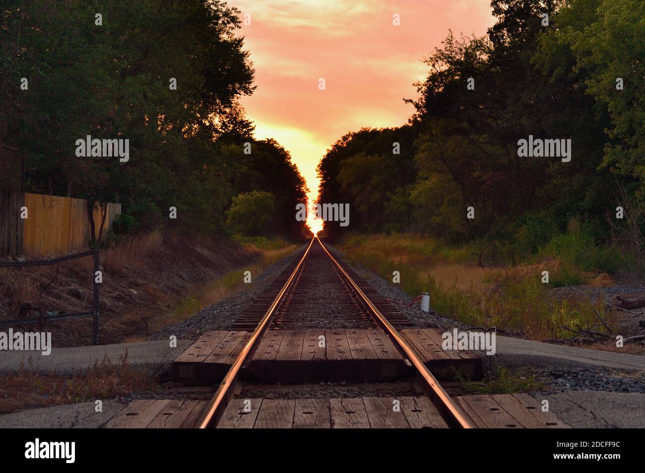 Burlington, Illinois, Stati Uniti. I binari ferroviari non occupati si estendono fino a un punto di fuga all'orizzonte poco prima del tramonto. Foto Stock