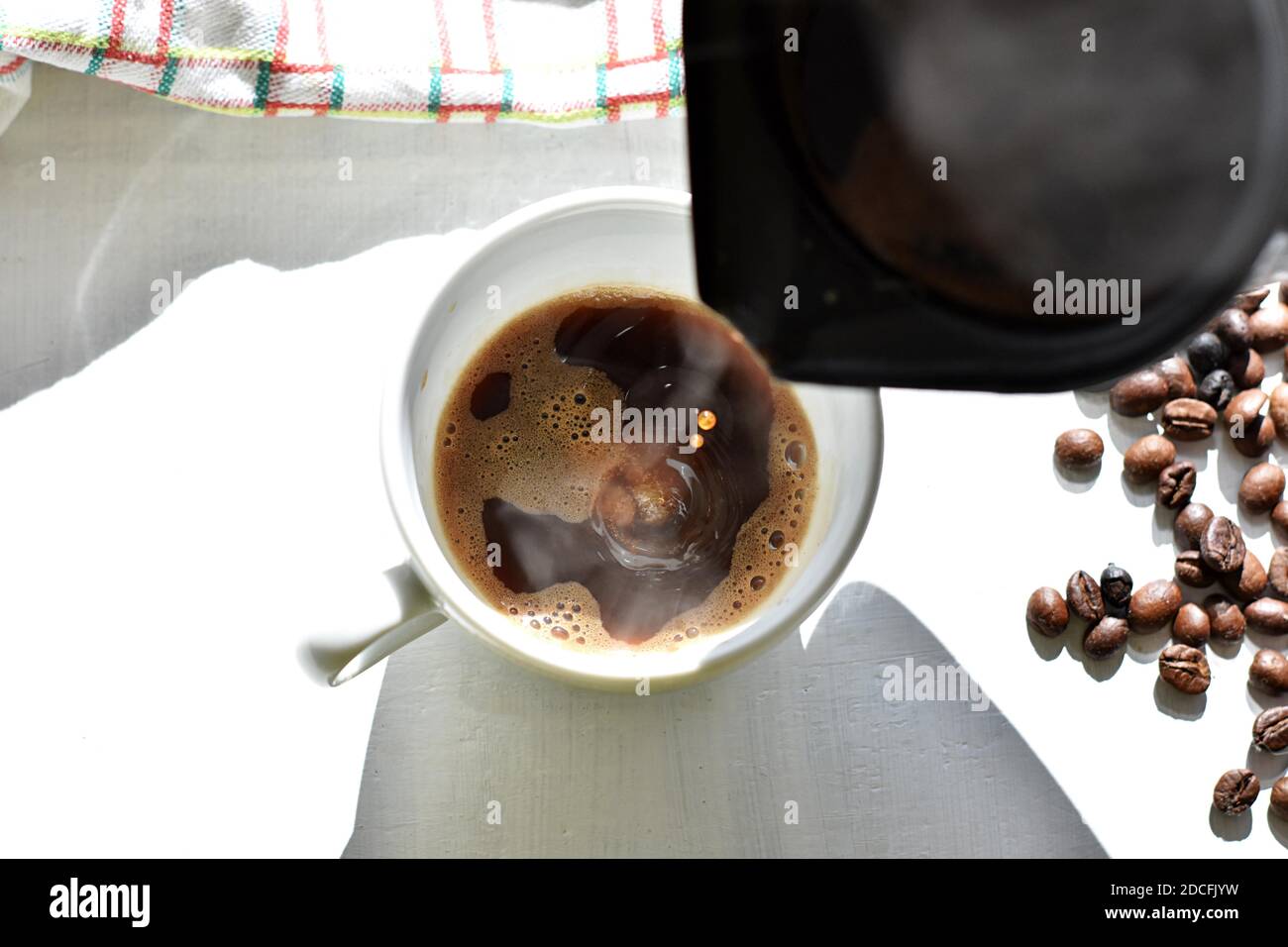 Svegliatevi con caffè espresso, versando caffè nero caldo nella tazza/ caffè turco nero caldo per colazione Foto Stock