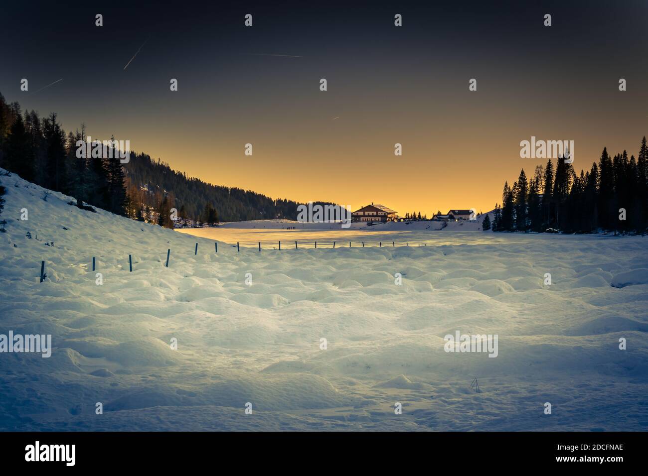 Panorama invernale del Lago Calaita al crepuscolo. Lago ghiacciato, boschi di abeti e prati innevati. Val di Lozen, Trentino-Alto Adige Foto Stock