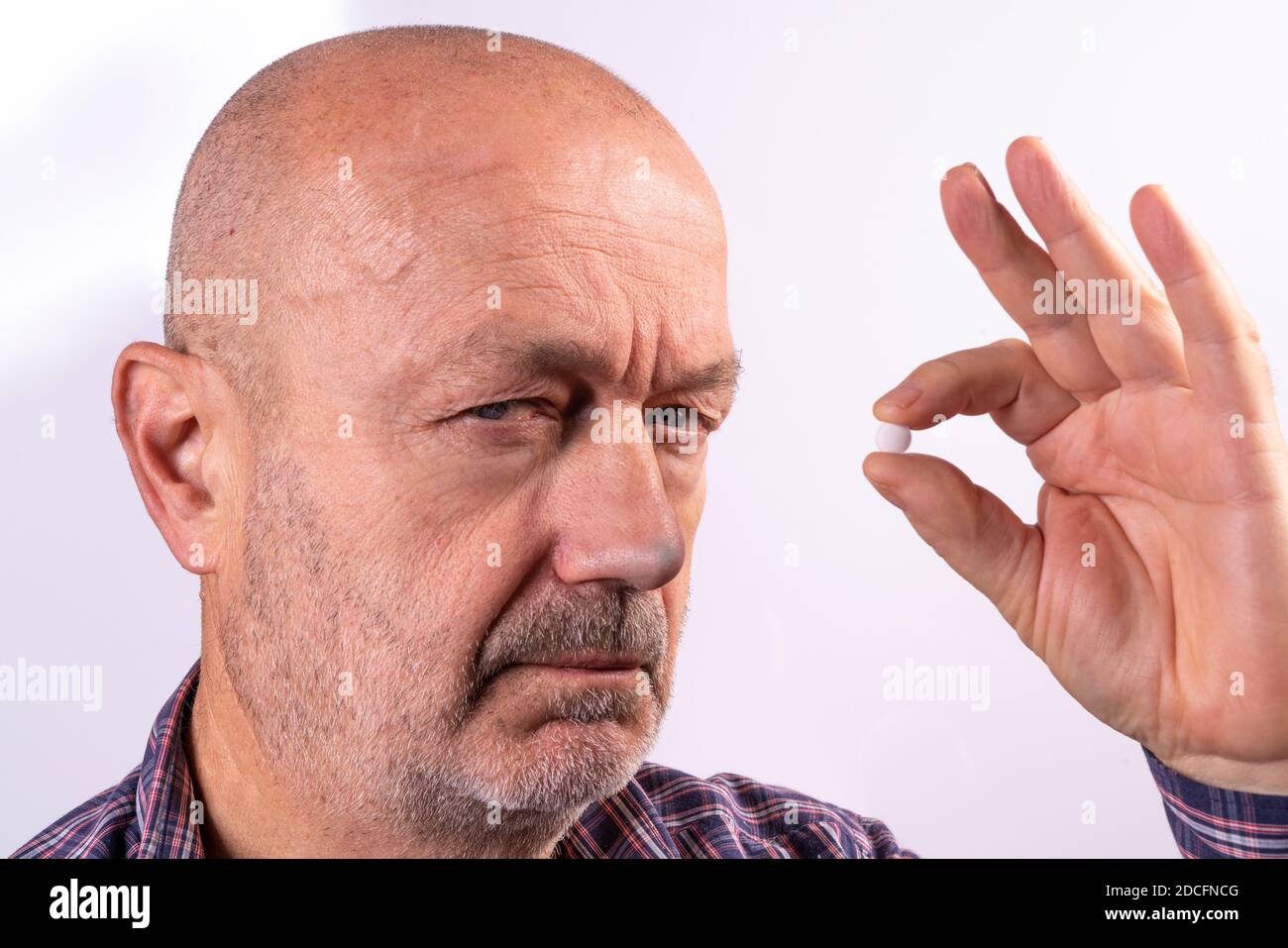 un uomo in dolore con una pillola in mano Foto Stock