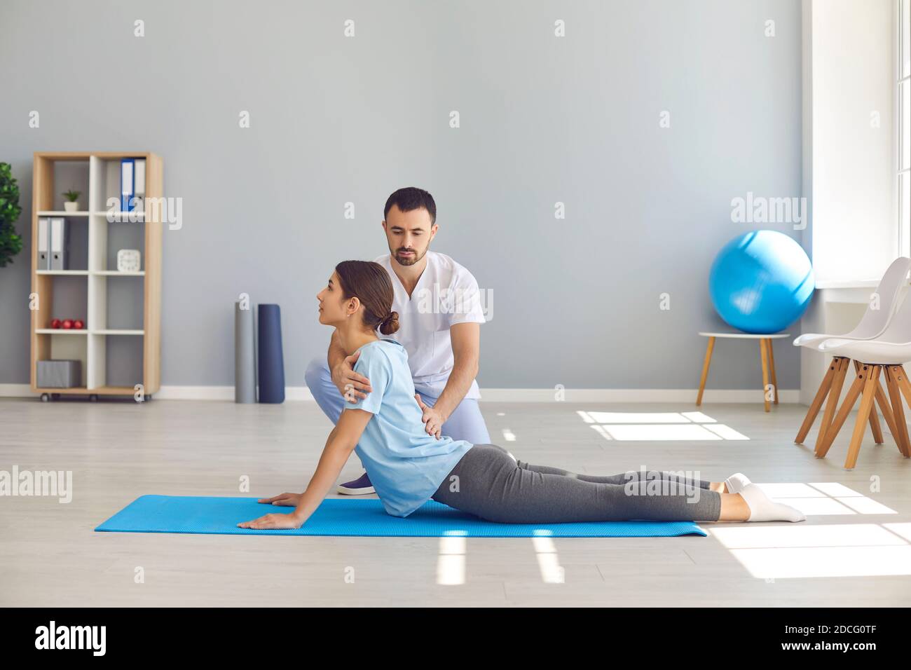 Donna che fa esercizio per ripristinare la flessibilità posteriore durante la fisioterapia dopo lesioni sportive Foto Stock