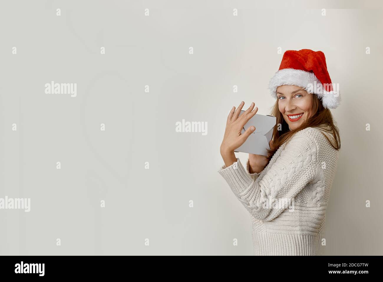 Ritratto di bella giovane donna in cappello di santa con un regalo Foto Stock