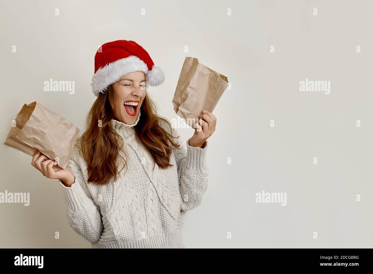 Ritratto di bella giovane donna in cappello santa tenendo carta borse Foto Stock