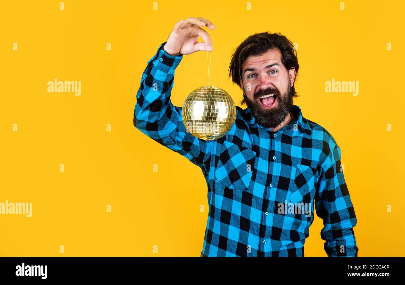 uomo casual con palla da discoteca brillante. uomo divertente e gioioso che si diverte in festa. tempo per divertimento. hipster bearded pronto a festeggiare la vacanza. concetto di arredamento per le vacanze. spazio per la copia. Foto Stock