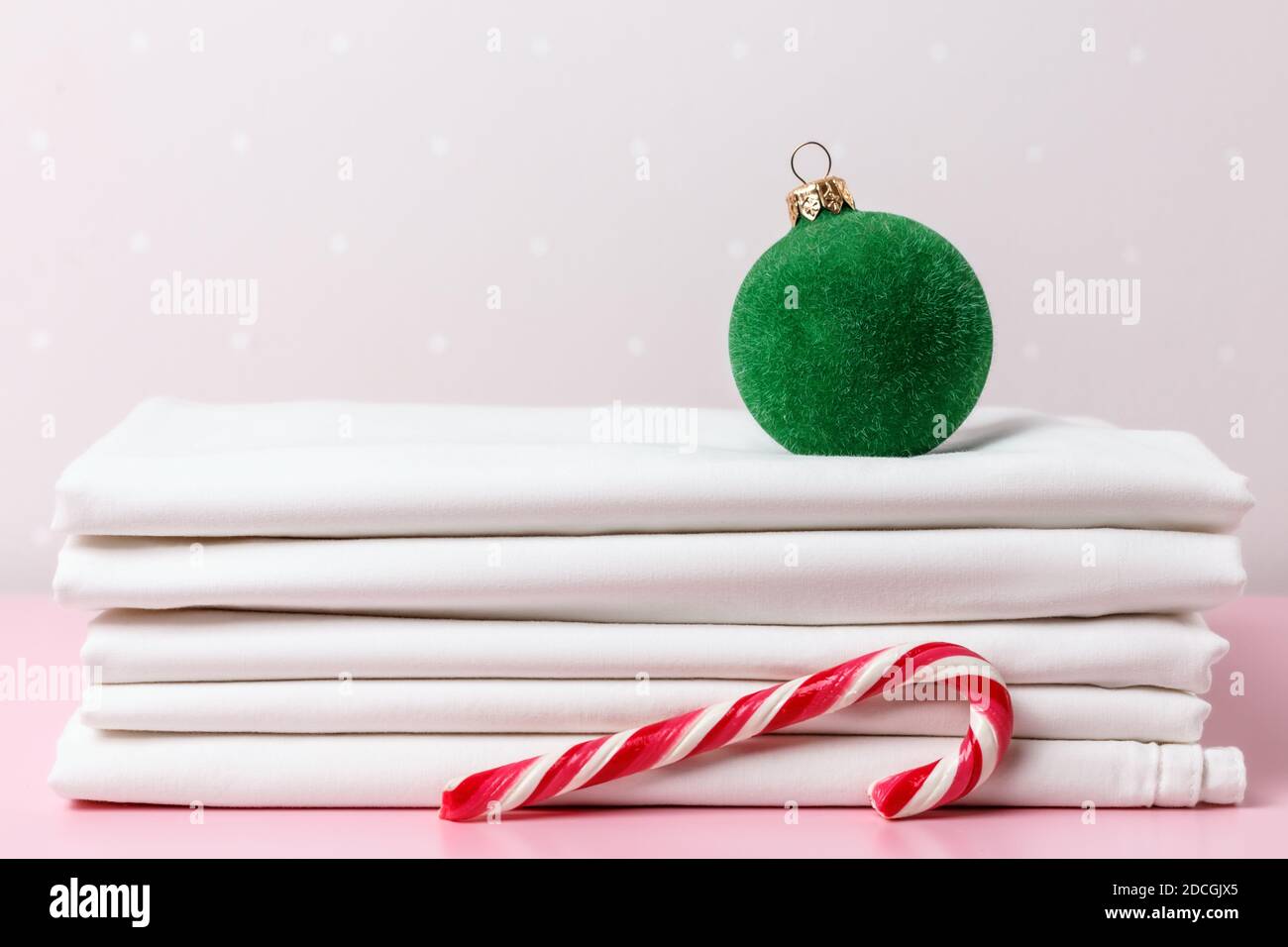 Una pila di fogli bianchi puliti, una sfera dell'albero di Natale e una canna della caramella. Foto Stock