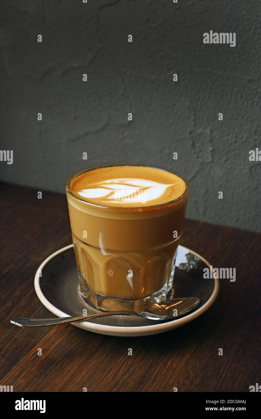 Glas di caffè latte e tulipano arte latte su un tavolo in legno .offee cafe latte art tulipano Foto Stock