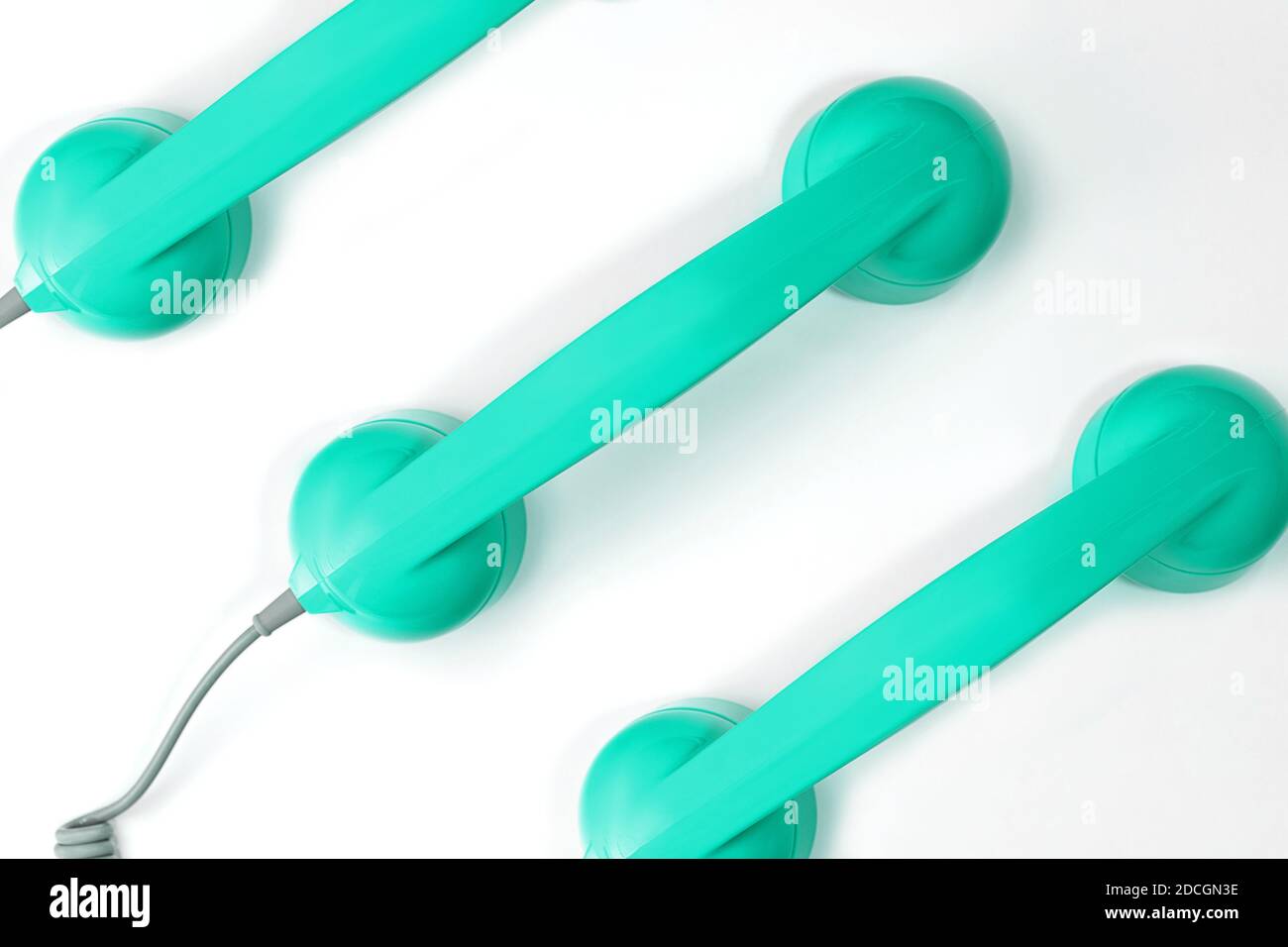 Modello realizzato con cornetta color menta verde neo di un telefono su sfondo bianco. Moderno stile retrò. Nuova vecchia tecnologia. Foto Stock