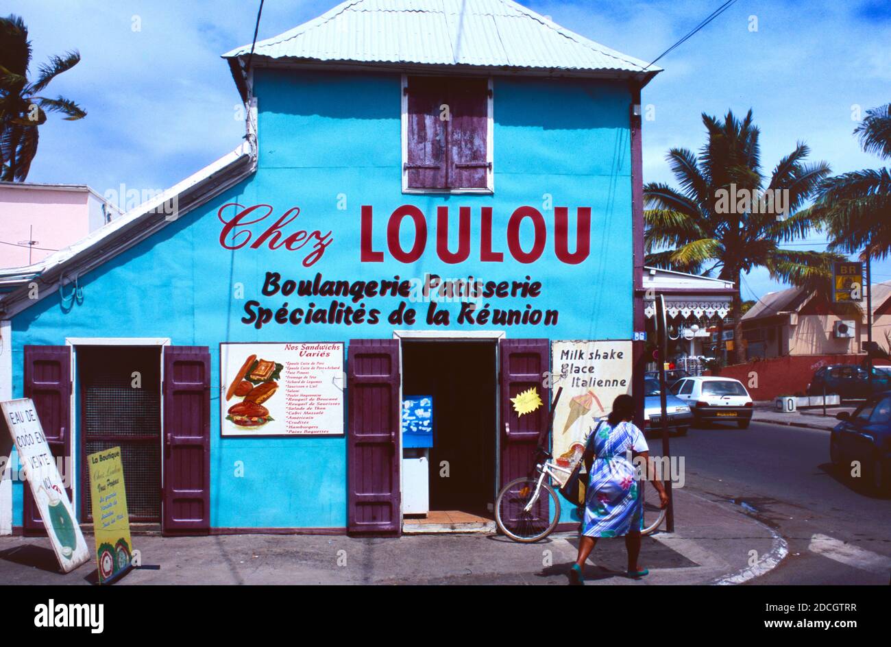 Locale Creole Woman passeggiate oltre il Chez Loulou Boulagerie o. Panificio a Saint Gilles o Saint-Gilles-les-Bains la Reunion o Reunion Isola Francia Foto Stock