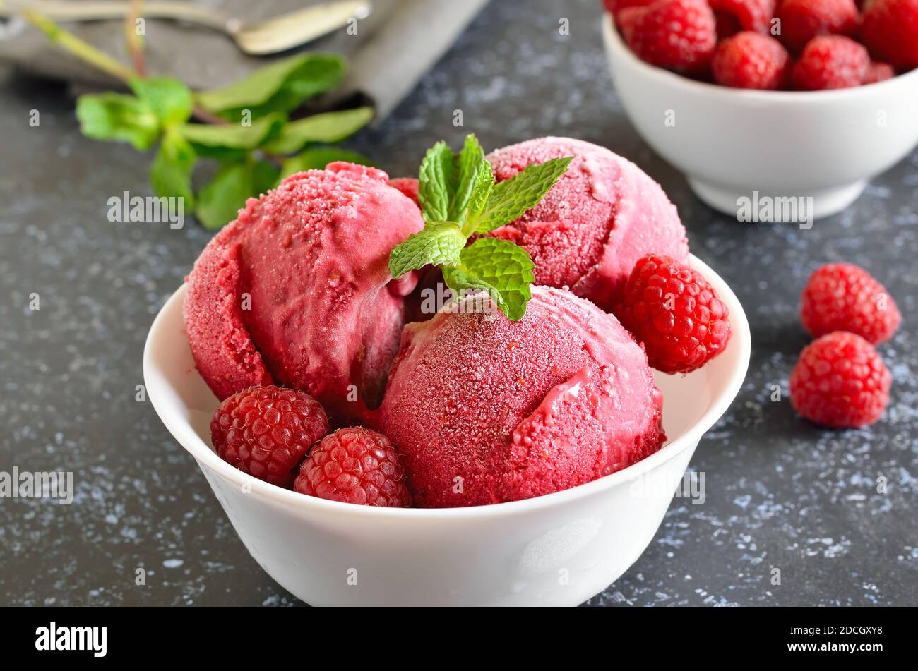 Paletta per gelato al lampone nel recipiente, vista ravvicinata. Dessert estivo freddo Foto Stock