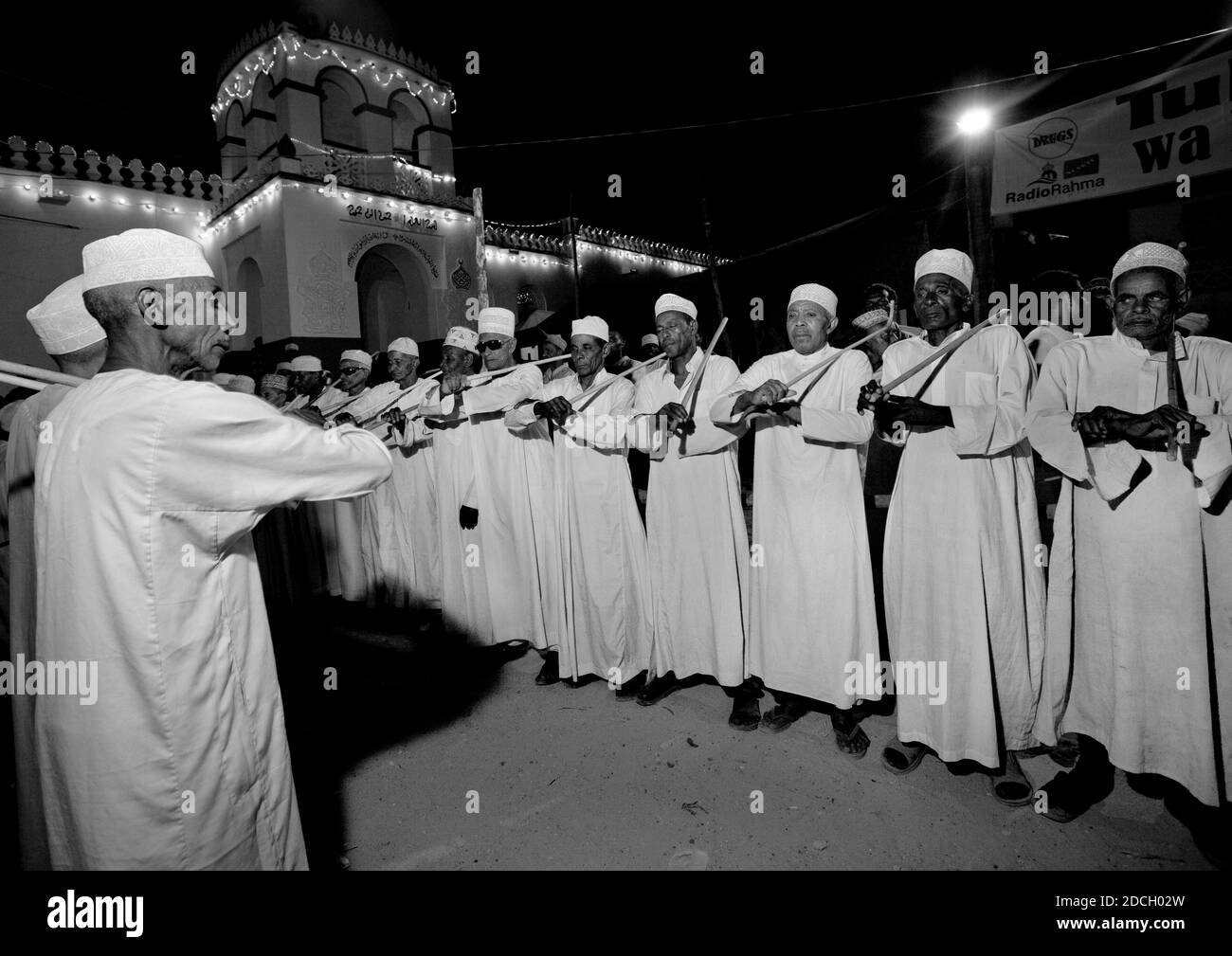 Uomini musulmani che cantano e ballano con bastoni di goma durante il festival di Maulid, Lamu County, Lamu, Kenya Foto Stock