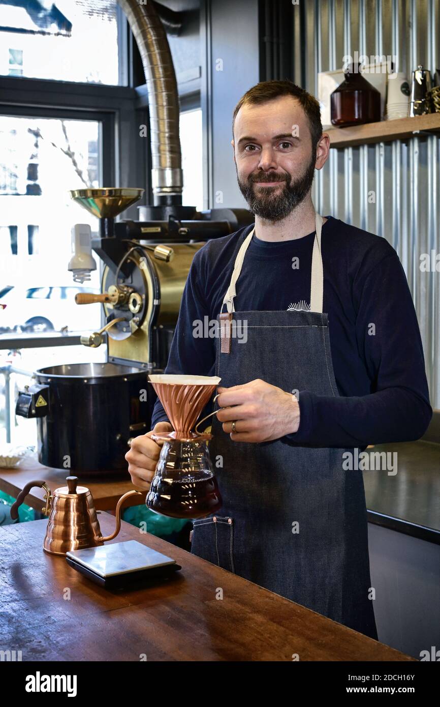 Gran Bretagna / Inghilterra /Sussex/ Brighton/caffè / caffè tostatore che fa il caffè filtro con V60 cucchiaia di caffè in rame in caffetteria. Foto Stock