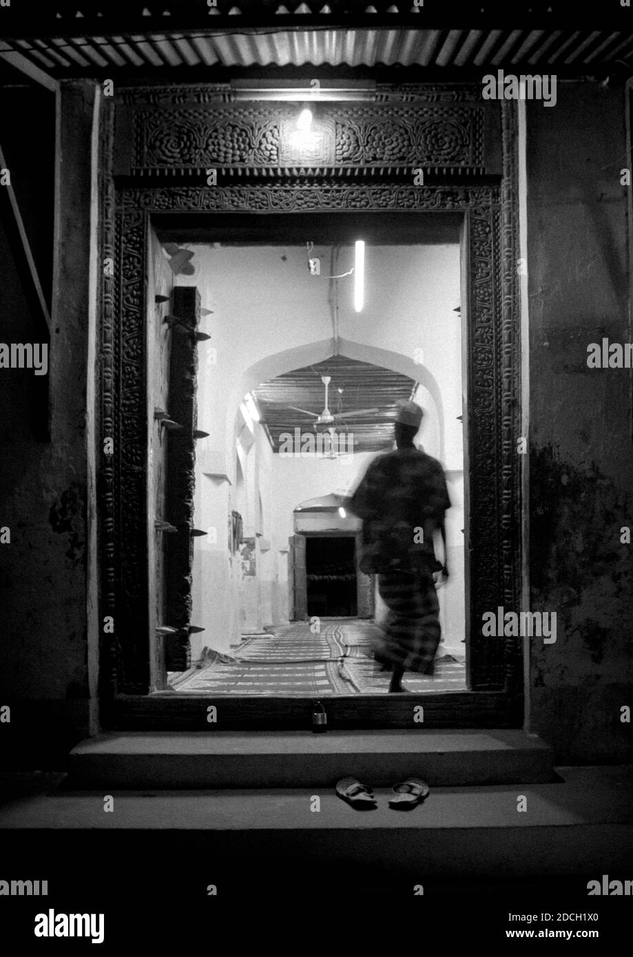 Uomo musulmano che entra in una moschea di notte, Lamu County, Lamu, Kenya Foto Stock