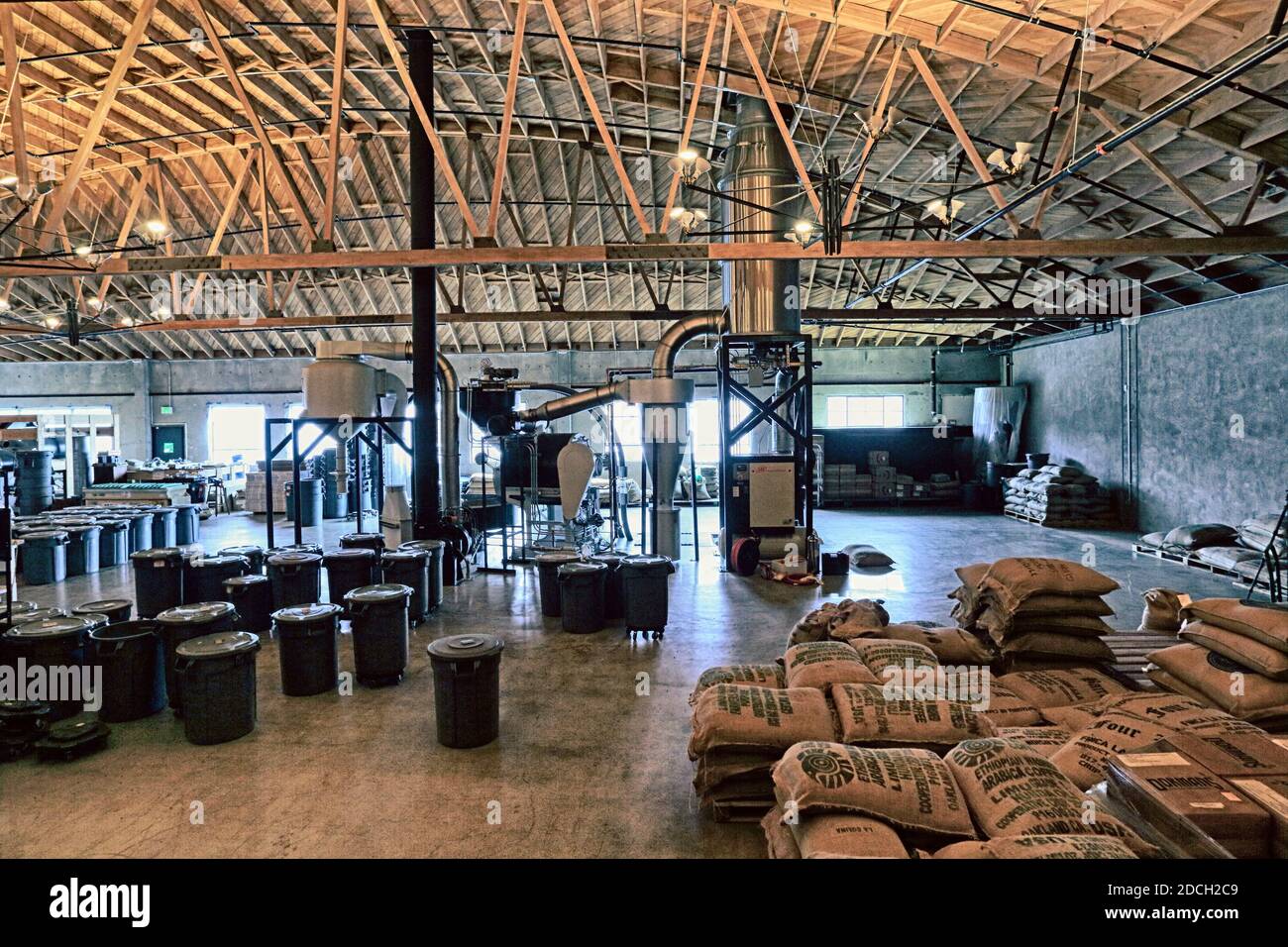 STATI UNITI / California / Oakland / magazzino con chicchi di caffè imballati in sacchi di burlap e struttura di tostatura. Foto Stock