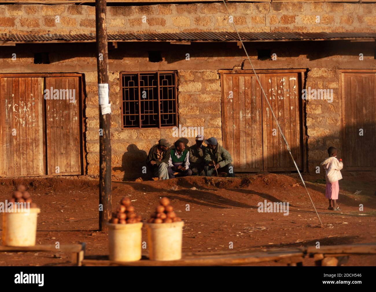 Uomini kenioti che chiacchierano di fronte a un edificio, nella contea di Nakuru, Nakuru, Kenya Foto Stock