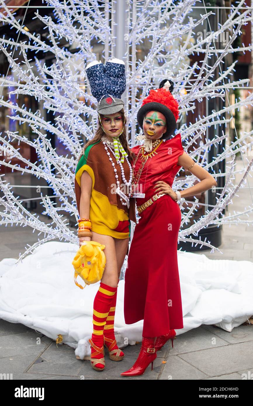 I modelli mostrano i vestiti dello stilista Pierre Garroudi insieme a un albero di Natale durante un flashmob fashion shoot a Oxford Street, Londra. Foto Stock